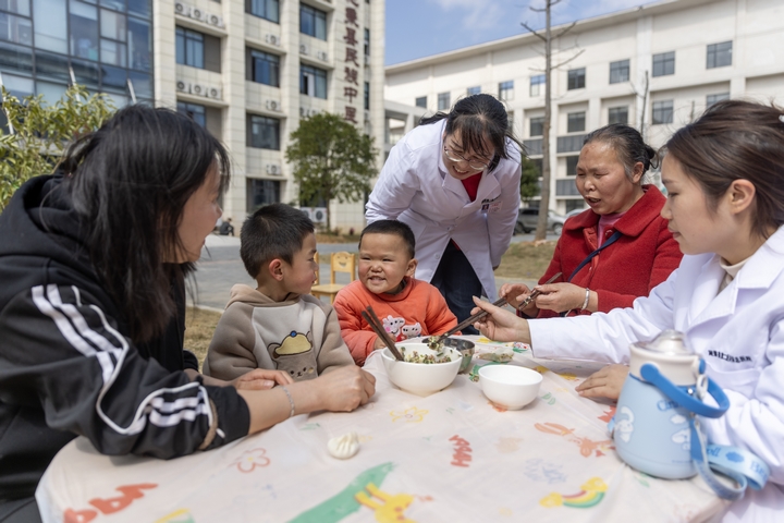 2025年2月28日，貴州省黔東南苗族侗族自治州施秉縣第二醫共體總醫院兒童康復科護士與家長一起指導孩子包餃子。（磨桂賓 攝） (3).jpg