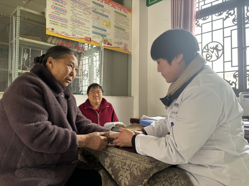 謝厚芝在給村民看病。