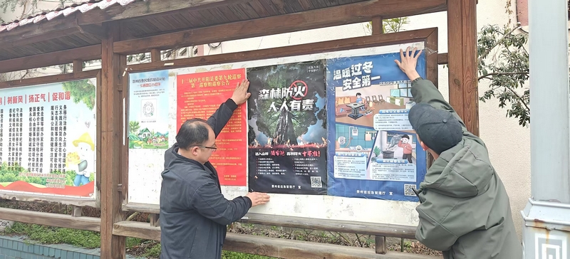 工作人員張貼森林防火相關海報 。吳小龍攝