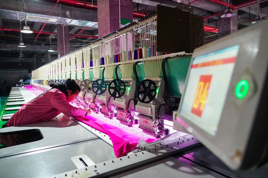 在貴州省從江縣美娥社區一家民族刺繡企業生產車間，工人在用數控機床生產刺繡產品。