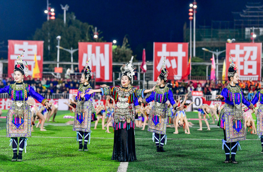 2025年3月14日，2025年貴州“村超”40強交叉賽在榕江“村超”足球場舉行，演員在比賽間隙表演侗族大歌，民族文化伴隨著體育賽事成功“出圈”。圖片來源：新華社