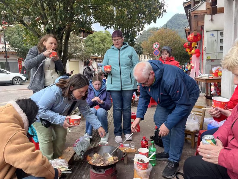  圖為海外游客在當地體驗婚禮“吃席” 。莫筆妙攝