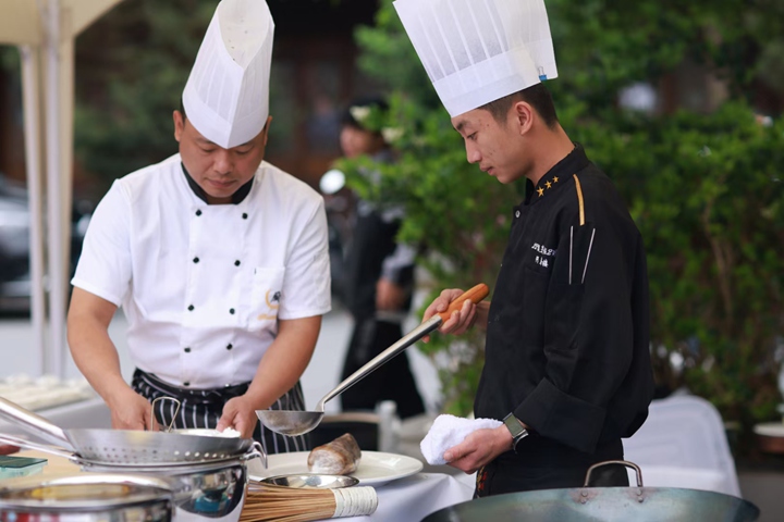 圖為廚師精心烹飪美食。