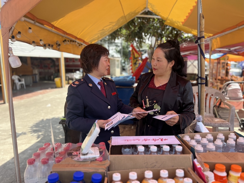 丹寨縣稅務局稅務干部向景區商戶開展稅收普法，引導其合規經營。吳珊珊攝