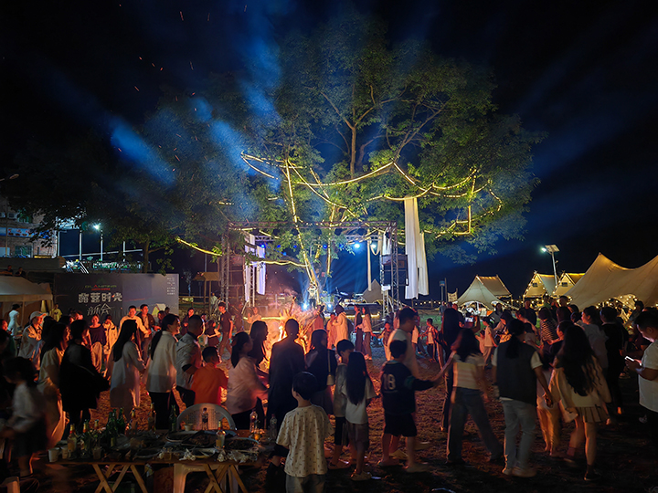 4、游客夜晚圍坐篝火旁，品嘗燒烤、仰望星空，沉浸于“時光音樂會”的民謠彈唱中。王琨榮攝