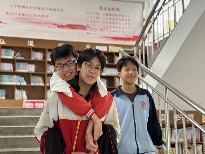 陳璟天背著方證淇走在路上，羅順洋陪在一旁。肖年童攝