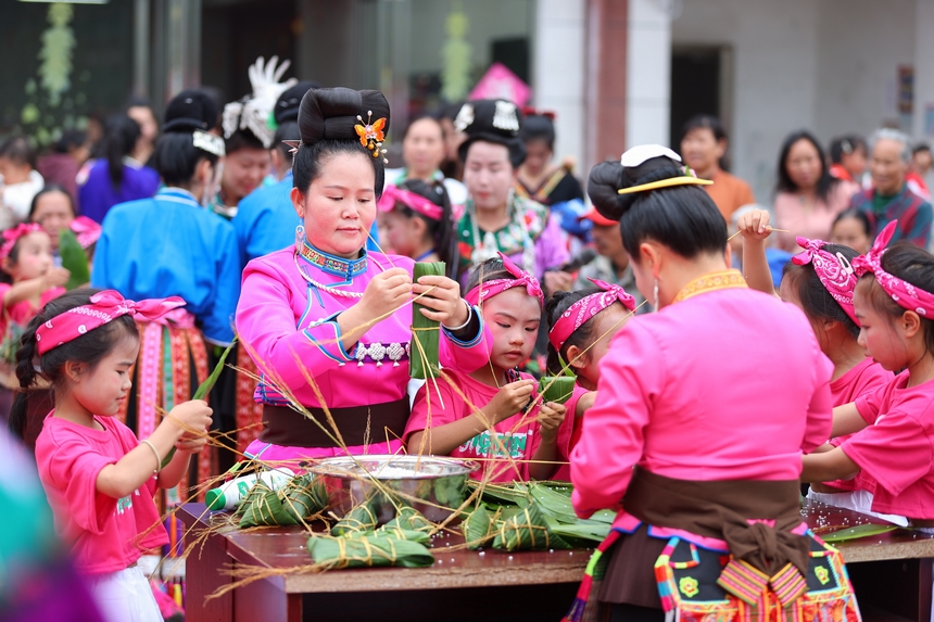 2025年5月29日，在貴州省丹寨縣金泉街道，身著傳統服飾的搬遷群眾在參加包粽子比賽。