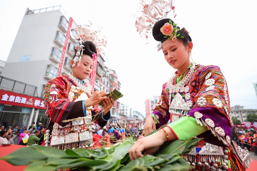 2025年5月29日，在貴州省丹寨縣金泉街道，身著傳統服飾的搬遷群眾在參加包粽子比賽。