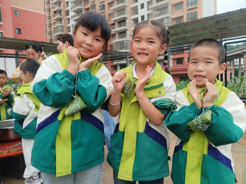 小朋友開心展示包好的粽子。