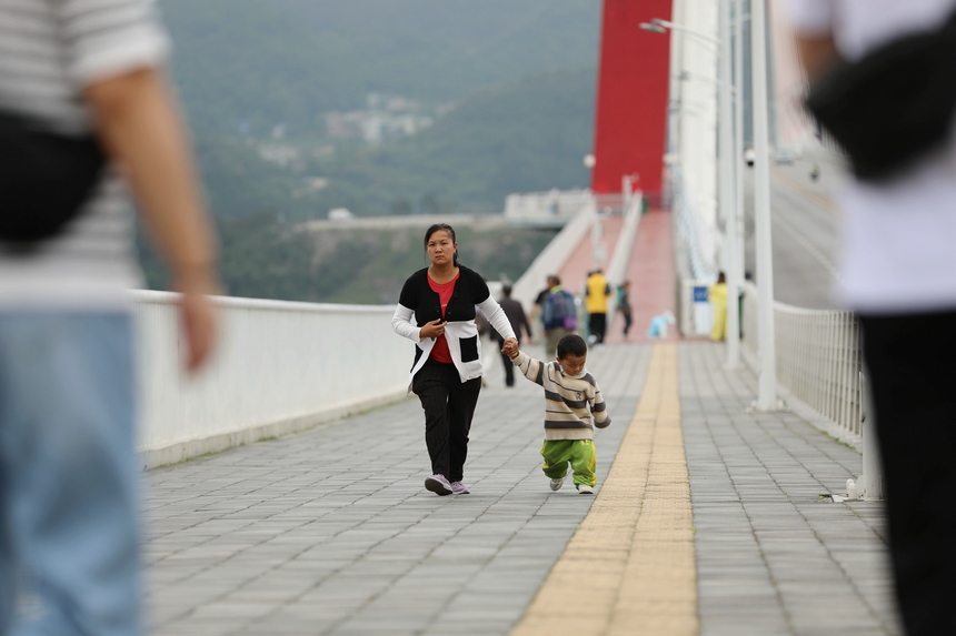游客行走在龍里河大橋上。
