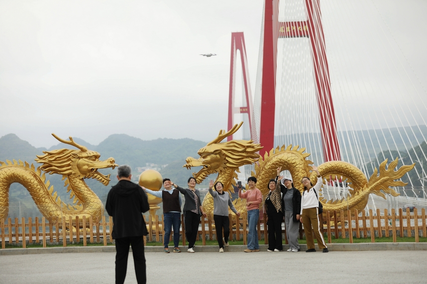 游客利用無人機記錄與龍里河大橋合影。