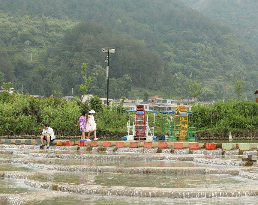 小朋友行走在魚鱗壩。