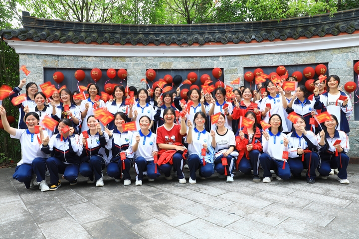 劍河民族中學高三學子手舉“金榜題名錦囊”在狀元亭旁合影。楊潔茹 攝