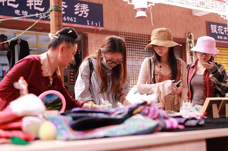 6月6日，在凱里市繡里淘非遺集市里，游客在挑選飾品。