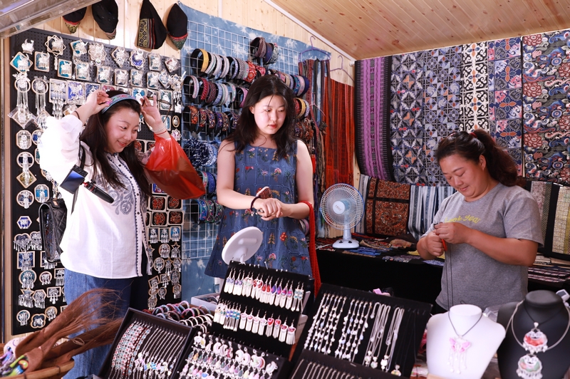 6月6日，在凱里市繡里淘非遺集市里，游客在挑選飾品。