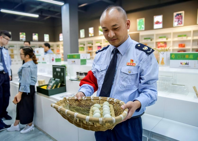 圖為國家稅務總局畢節高新區稅務分局派駐赫章雙坪鄉的第一書記周榮正為村民售賣雞蛋。村委會供圖