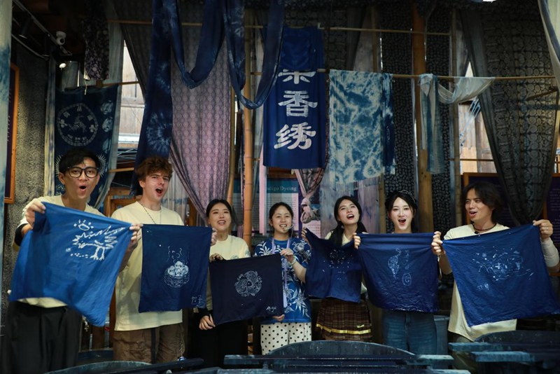 嘉賓們跟著村民陸玉梅學習蠟染。