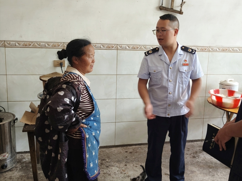 稅務干部徐偉走訪少仲村村民，了解危房改造后村民情況。陳友元攝