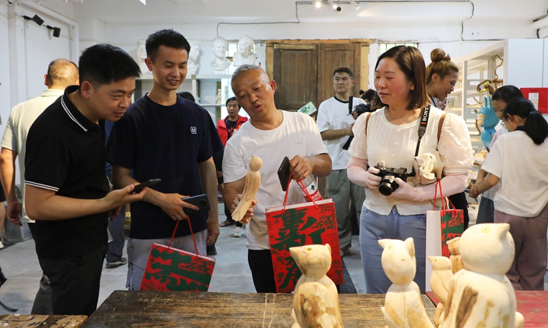 游客們駐足欣賞鄉土氣息濃郁的藝術作品。陳桂良攝