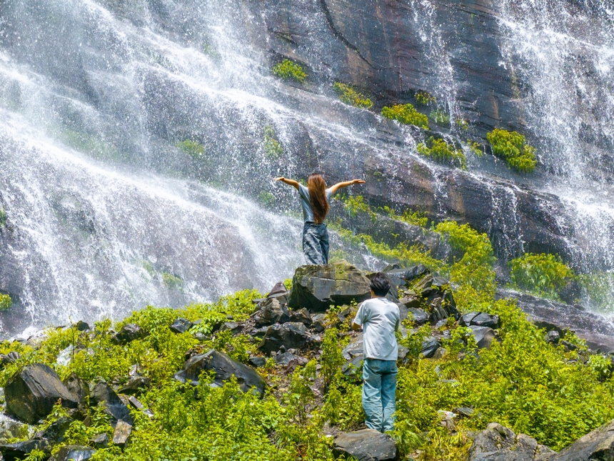 6月29日，游客在貴州省畢節市納雍縣吊水巖瀑布游玩打卡。