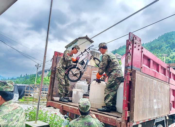 圖為，雷山縣武裝部派出的民兵應急分隊在永樂鎮加支村忙著幫助受災村民轉運家具。.jpg