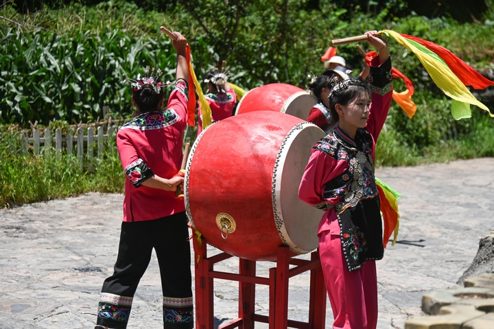 7月4日，人們在盤信鎮大灣苗寨的在打迎賓鼓。謝慧芳攝.JPG