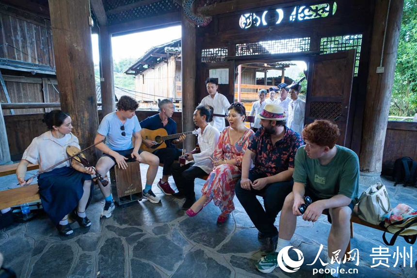 村民與游客坐在鼓樓里暢談侗族大歌。人民網 陽茜攝