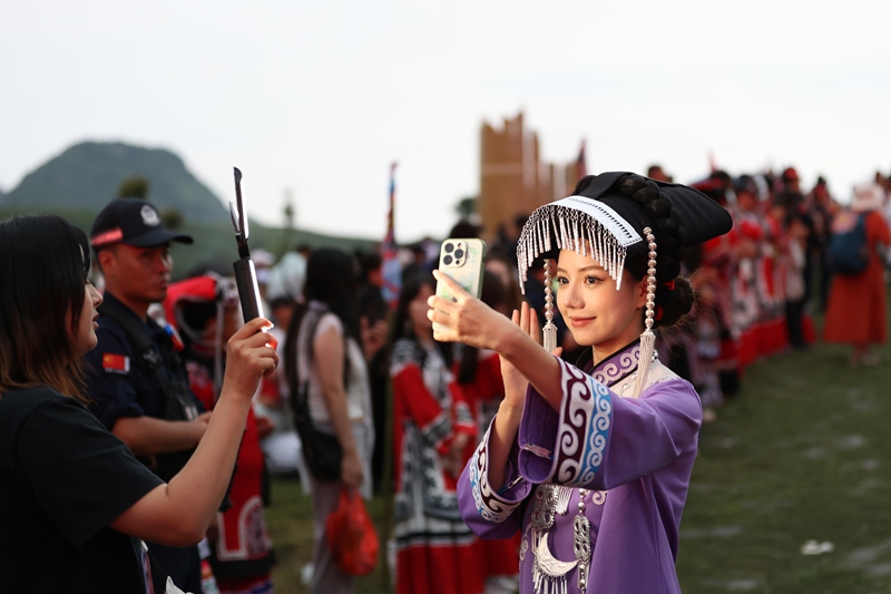 游客在貴州省畢節市赫章縣彝族火把節開幕式現場進行直播。