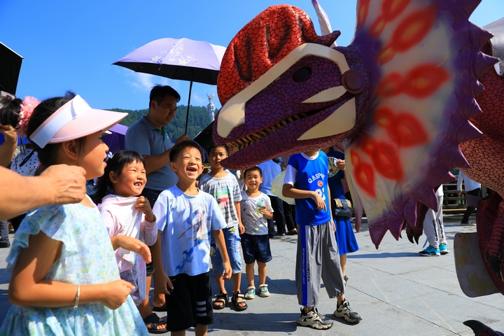 8月1日，貴州省劍河縣校場壩，小朋友們在和恐龍化石人偶互動。楊家孟 攝  (2).JPG