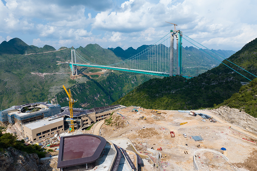 建設中的云渡服務區與遠處的大橋同框。人民網記者 涂敏攝