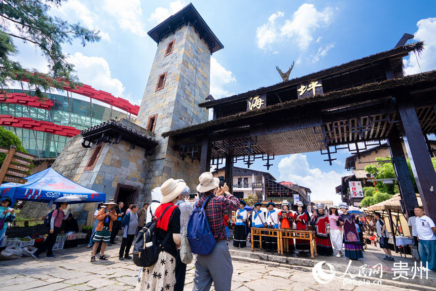 游客參觀體驗度假區內的彝族攔門酒。人民網記者 涂敏攝