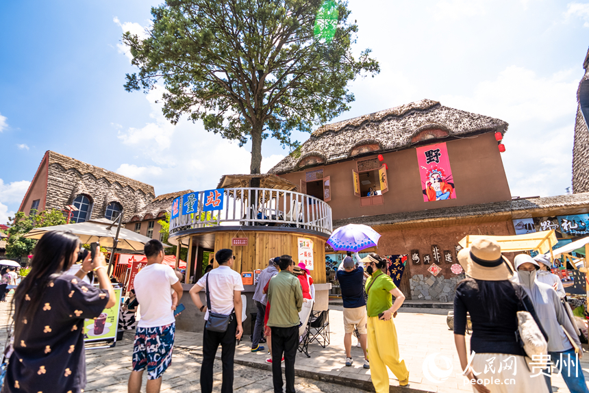 游客在景區內的海坪彝族特色旅游度假小鎮觀看表演。人民網記者 涂敏攝