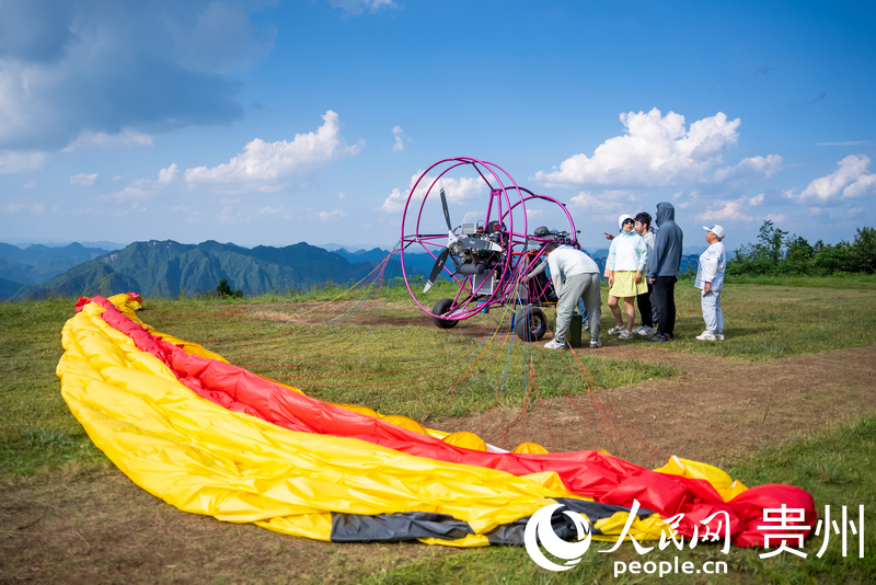 游客體驗動力滑翔傘飛行。人民網記者 涂敏攝