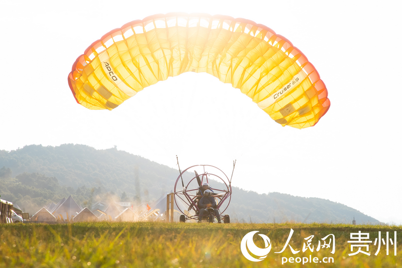 游客體驗動力滑翔傘飛行。人民網記者 涂敏攝