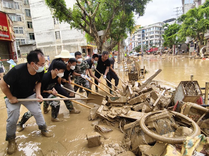榕江縣稅務干部清理網格責任區內淤泥。