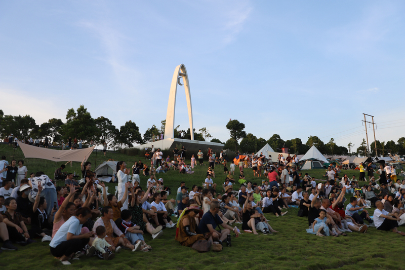 隨著音樂舞動雙手的游客。查姜維攝