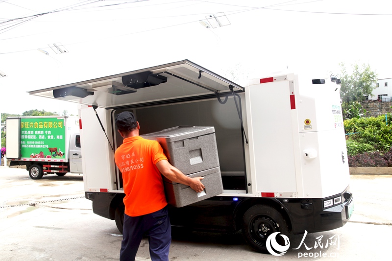 在貴陽家旺興食品有限公司，搬運人員正在給無人配送車裝貨。人民網記者 王秀芳攝