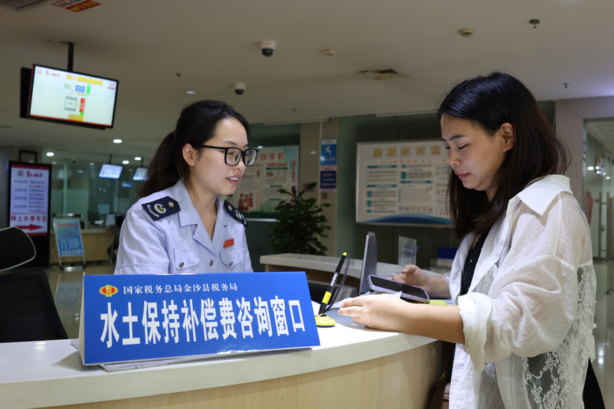 近日，國家稅務總局金沙縣稅務局在辦稅大廳開設水土保持補償費咨詢窗口。圖為稅務工作人員正在為前來咨詢的納稅人繳費人解答相關問題。朱泫粼攝
