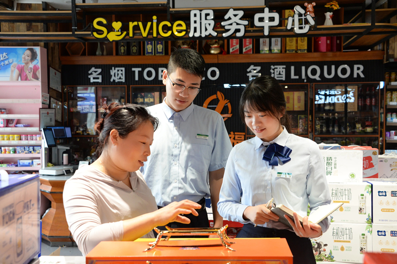 郵儲銀行工作人員走訪卷煙商戶獲取其資金需求。郵儲銀行貴州省分行供圖