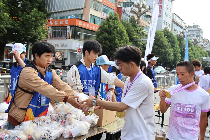志愿者為完賽運動員發放補給包。王永勝攝
