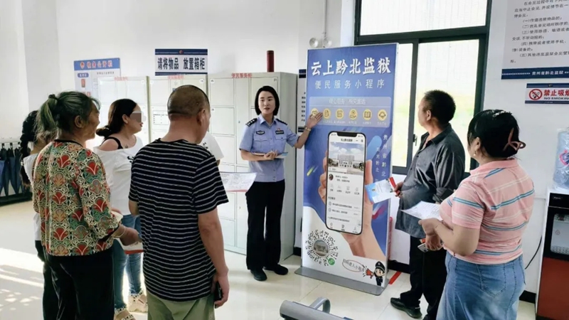 民警在為罪犯家屬講解“云上黔北監獄”小程序使用方法。