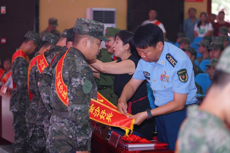 前排領導為入伍新兵佩戴紅花和綬帶，彰顯榮譽與關懷。 (2)