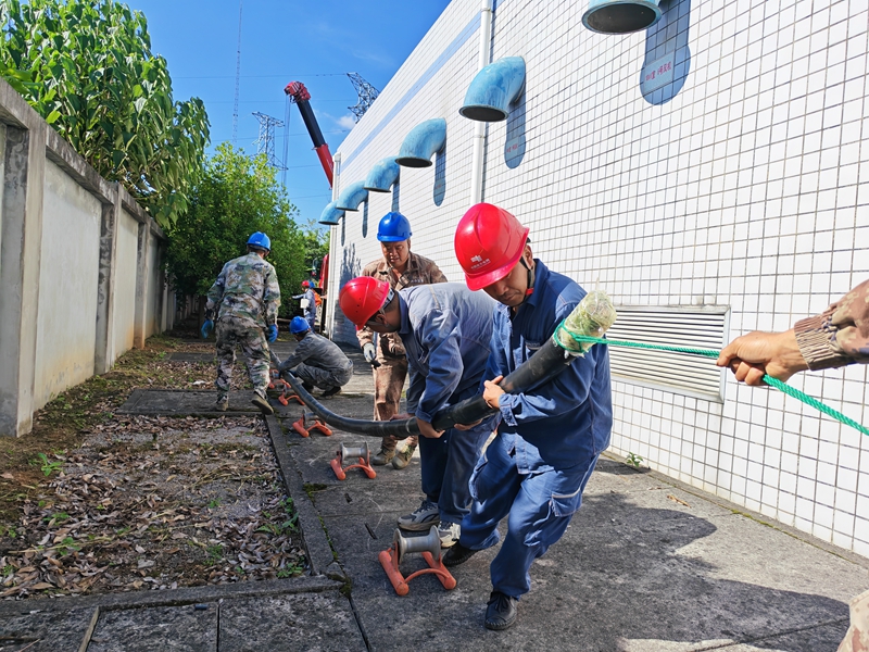 圖為：南方電網興義興仁供電局工作人員對變電站受損故障電纜進行更換