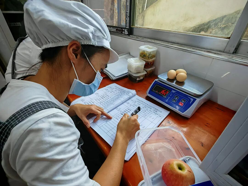 食堂工作人員對當日午餐進行取樣、留樣記錄.