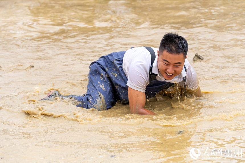 摸魚比賽現場，參賽選手在水中摸魚。人民網記者 涂敏攝