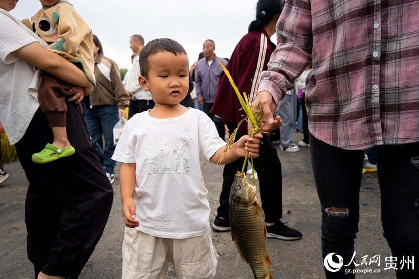 摸魚抓鴨子比賽結束后，小朋友拎著家長的戰利品。人民網記者 涂敏攝