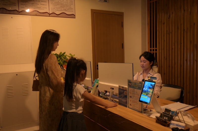 在仁懷市長崗鎮藺田村塵外楠山民宿接待大廳，游客正在辦理入住。