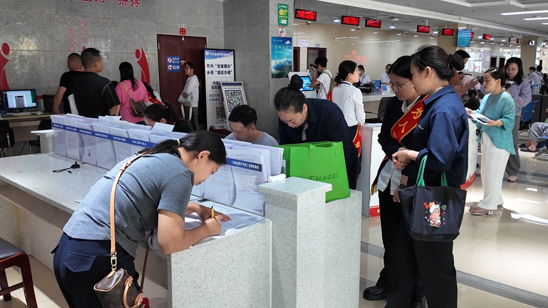 協助辦事群眾填寫資料。王璽 攝.jpg