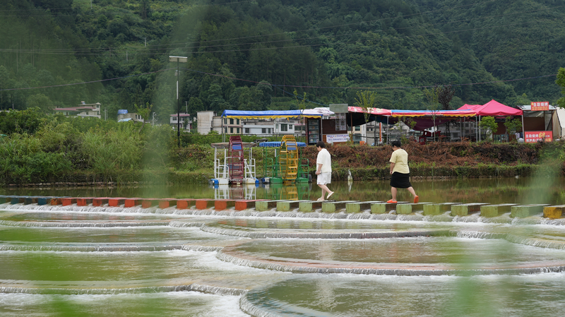 游客行走在龍里縣龍山鎮余下村魚麟壩。