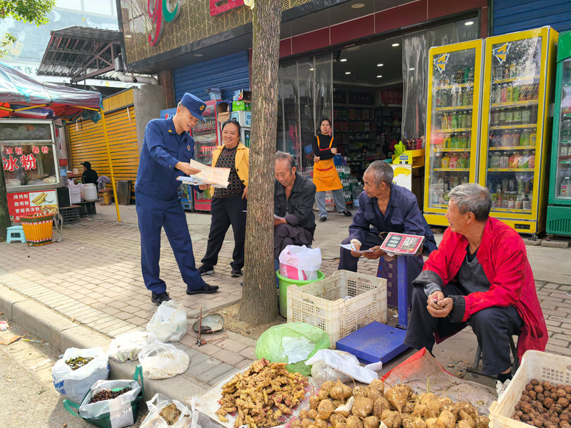 消防員向攤主和趕集群眾講解消防安全知識。